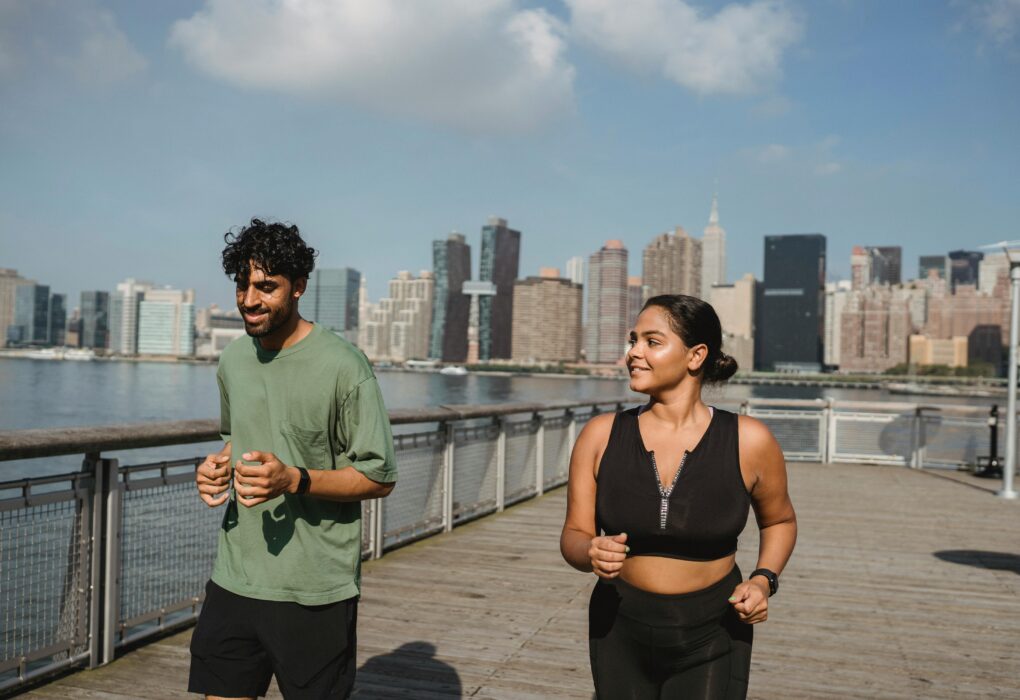 a man and woman running on a boardwalk