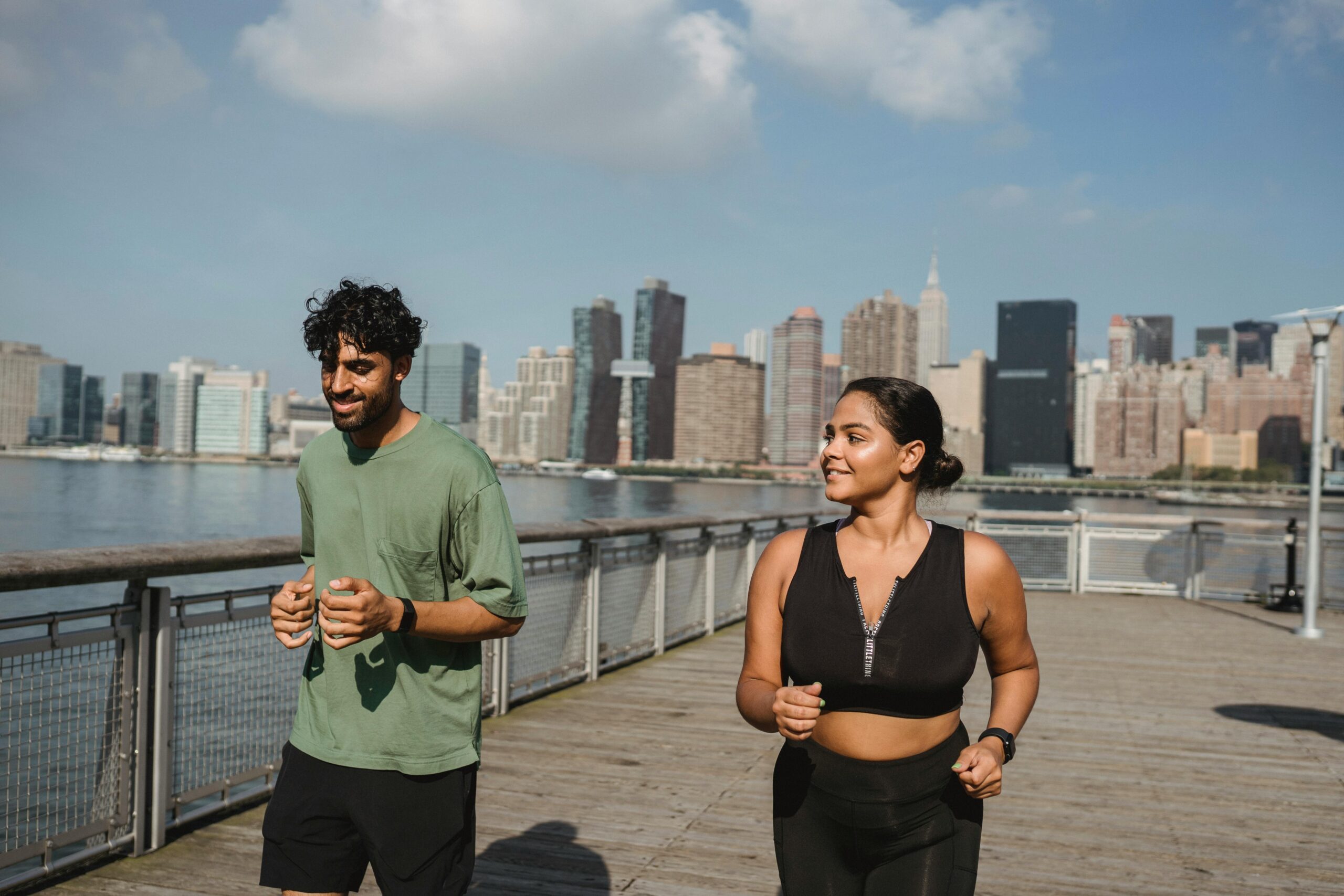 a man and woman running on a boardwalk